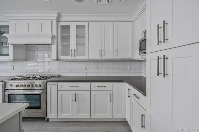 a kitchen with white cabinets and a stove