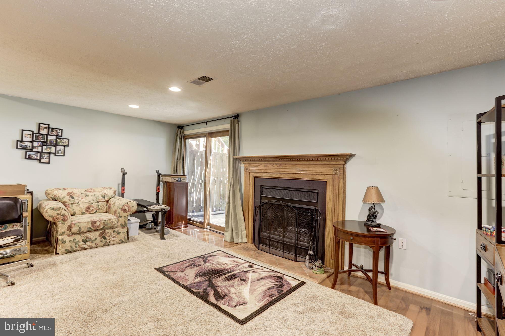 7365 Stream Way Springfield, VA 22152 - Photo 30 of 42 Cozy fireplace in the light filled lower level