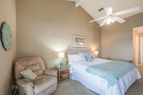 a spacious bedroom with a bed and a chandelier