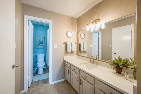 a spacious en suite bathroom with a double vanity sink and mirror