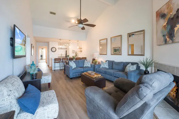 a living room with furniture a flat screen tv and wooden floor