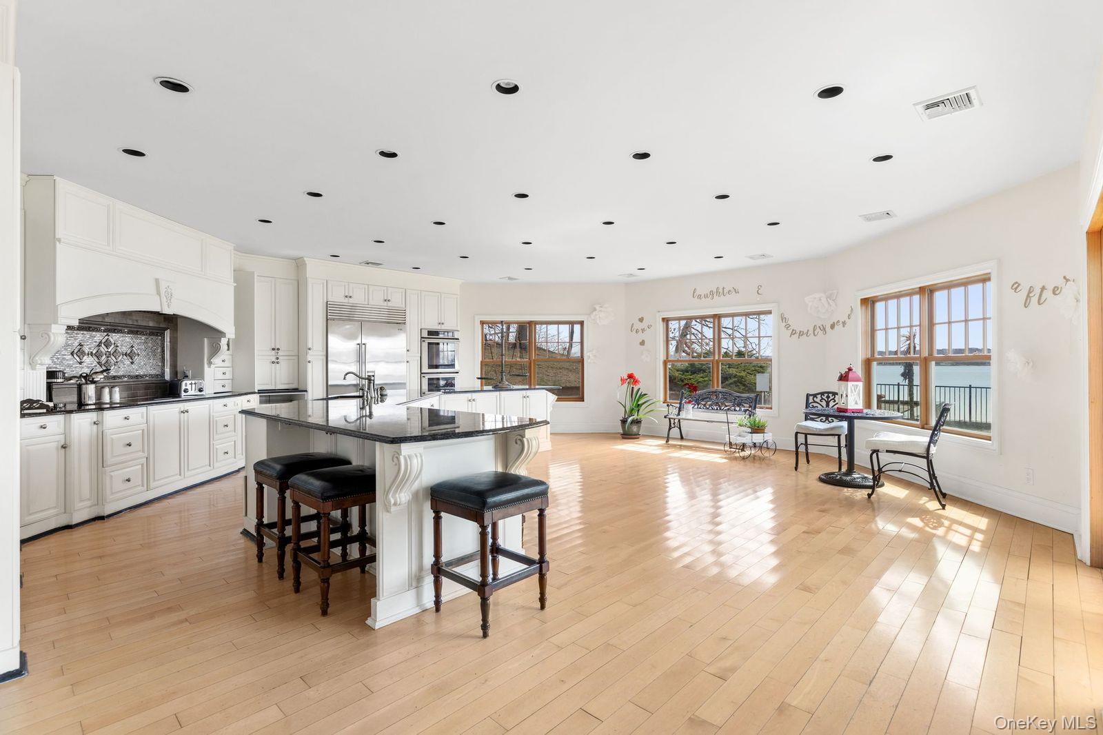 33 Beach Road Northport, NY 11768 - Photo 13 of 50 a kitchen with stainless steel appliances kitchen island granite countertop a table chairs sink and cabinets