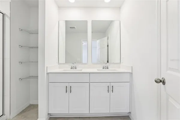 a bathroom with a double vanity sink and mirror