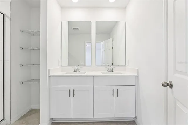 a bathroom with a double vanity sink and mirror
