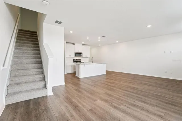 a view of kitchen with wooden floor and electronic appliances