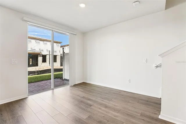 a view of empty room with wooden floor