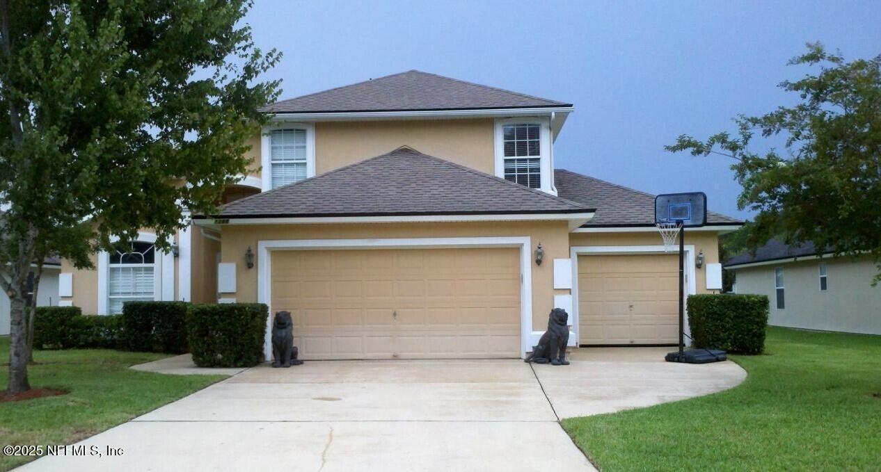 a front view of a house with a yard and a garage
