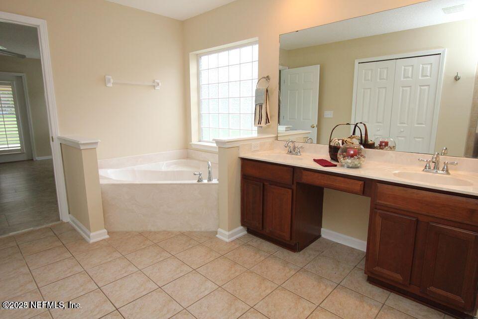 1288 Loch Tanna Loop St. Johns, FL 32259 - Photo 12 of 25 a bathroom with a double vanity sink a mirror and a bathtub