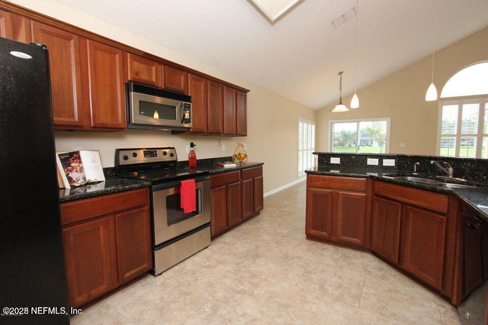 1288 Loch Tanna Loop St. Johns, FL 32259 - Photo 3 of 25 a kitchen with stainless steel appliances granite countertop a stove a sink dishwasher and a microwave