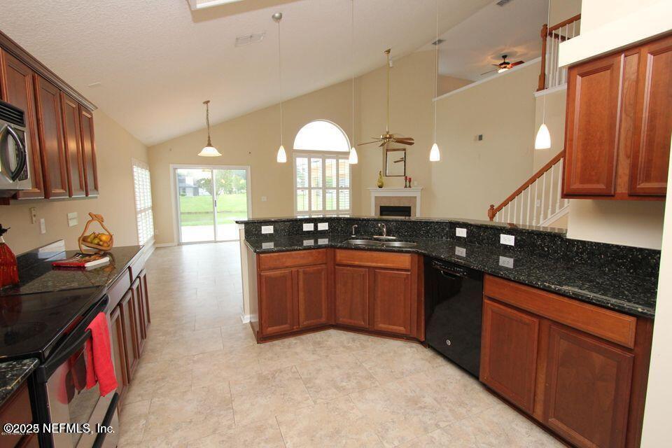 1288 Loch Tanna Loop St. Johns, FL 32259 - Photo 5 of 25 a kitchen with stainless steel appliances granite countertop a stove a sink and a microwave