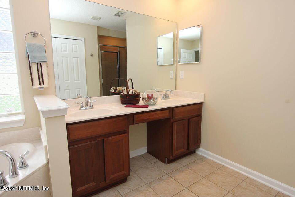 1288 Loch Tanna Loop St. Johns, FL 32259 - Photo 10 of 25 a bathroom with a sink vanity and mirror