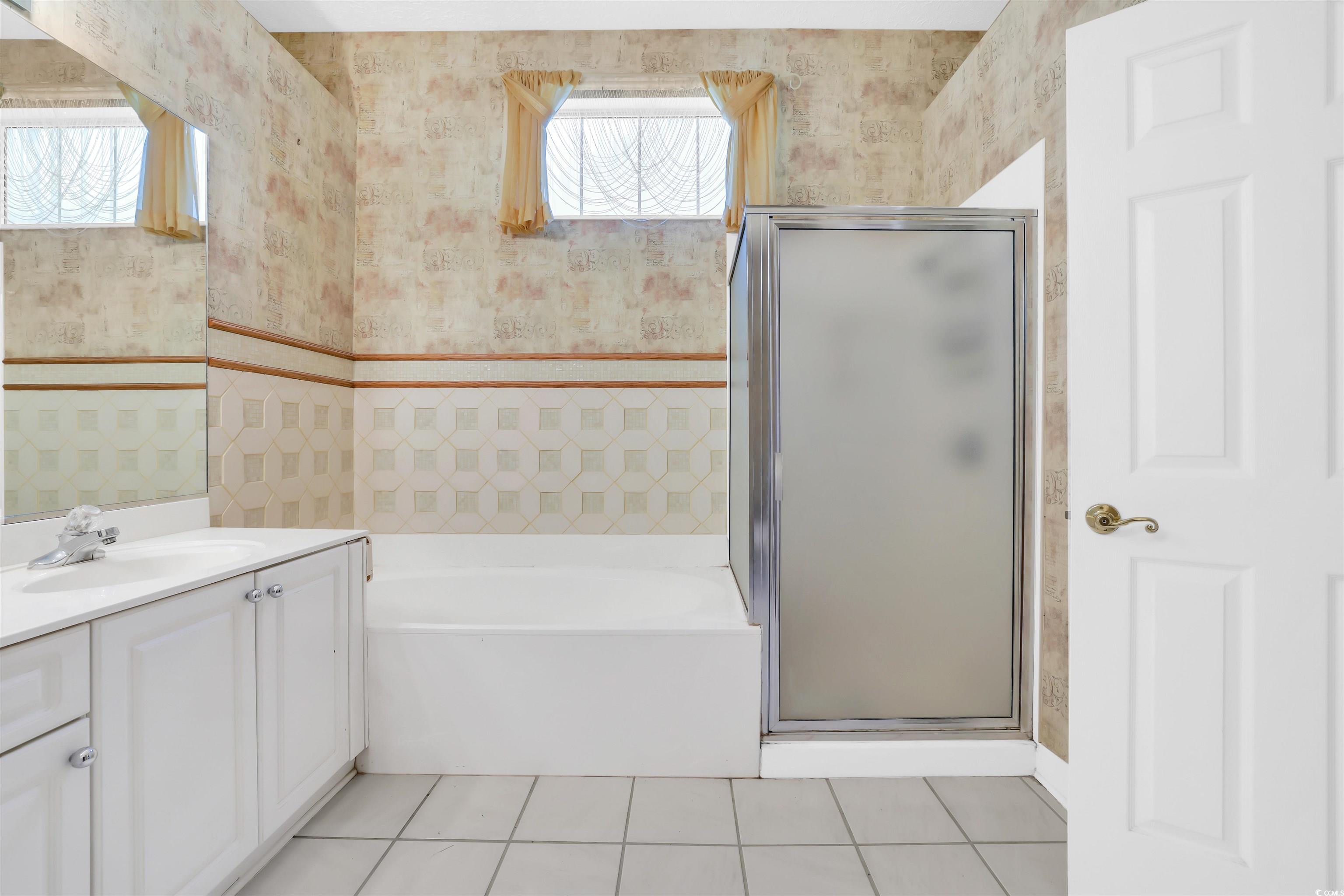 9350 Pinckney Lane Murrells Inlet, SC 29576 - Photo 18 of 40 Bathroom featuring wallpapered walls, light tile patterned floors, vanity, a bath, and a shower stall