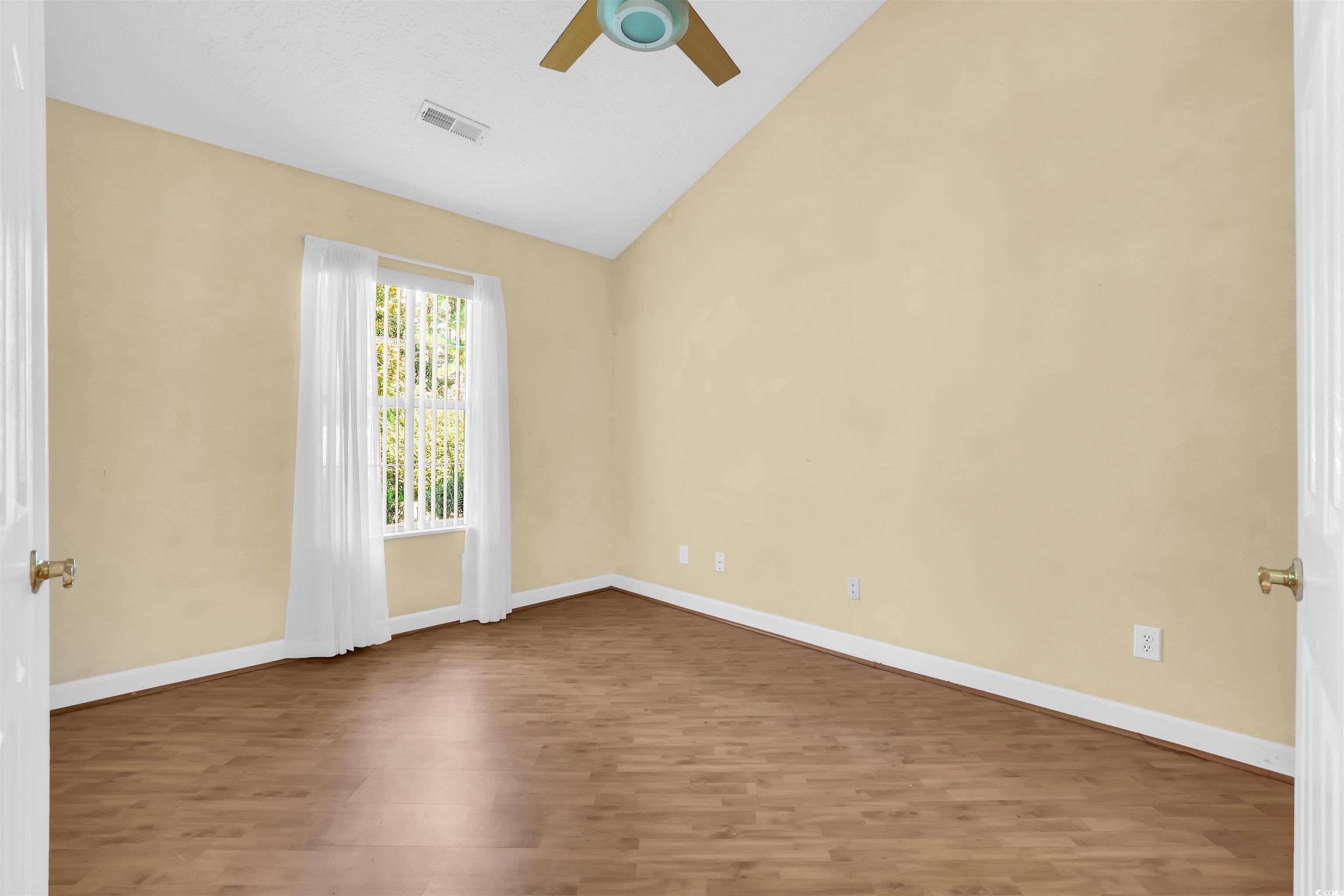 9350 Pinckney Lane Murrells Inlet, SC 29576 - Photo 23 of 40 Spare room featuring wood finished floors, a ceiling fan, and high vaulted ceiling