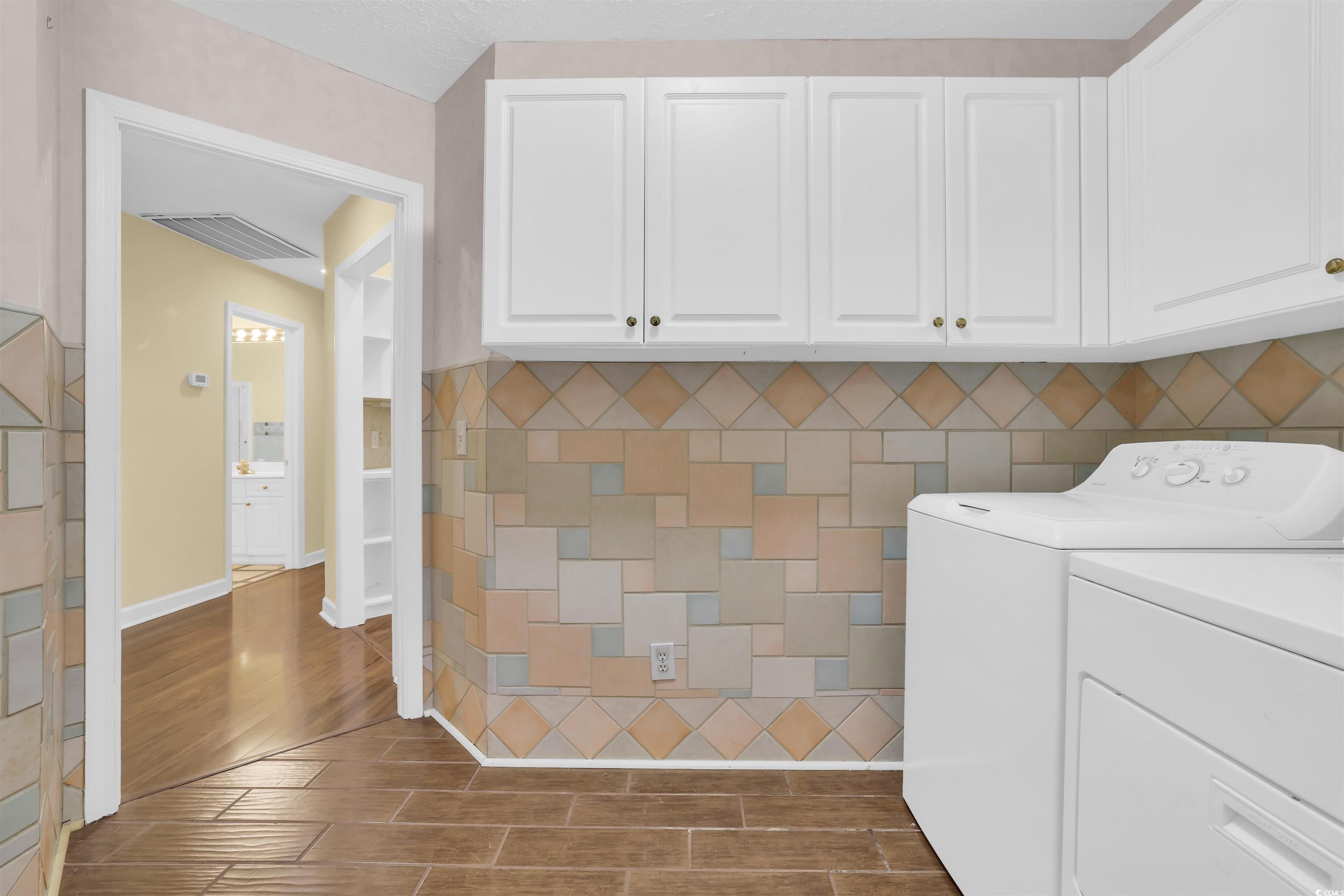 9350 Pinckney Lane Murrells Inlet, SC 29576 - Photo 31 of 40 Laundry area with cabinet space, wood finish floors, and independent washer and dryer
