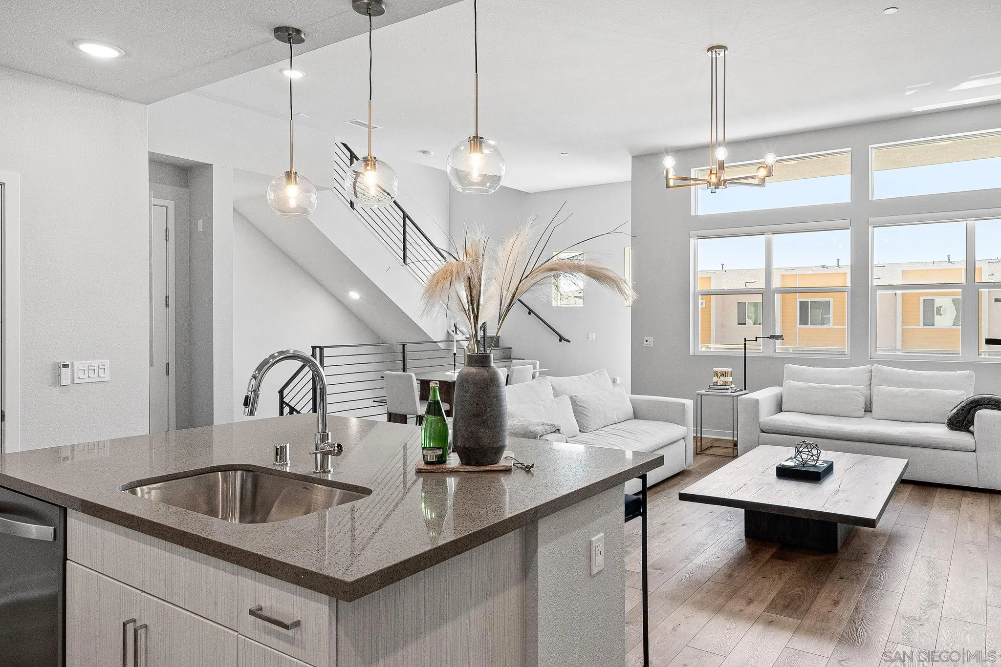3002 Bravo Loop, Unit 4 Chula Vista, CA 91915 - Photo 13 of 38 a living room with kitchen island furniture and a chandelier