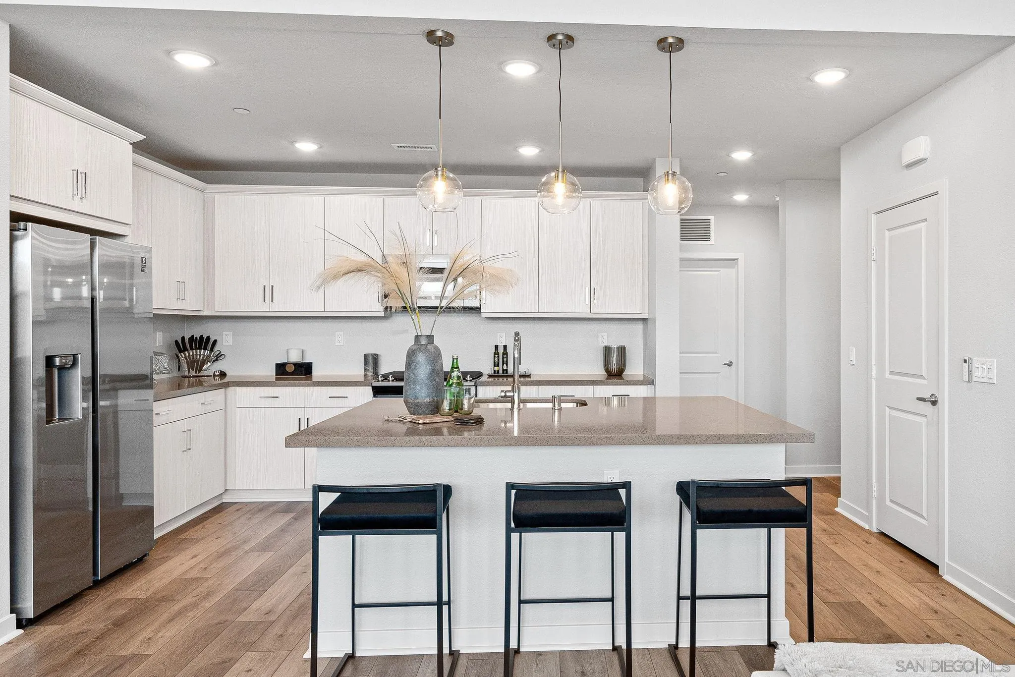 3002 Bravo Loop, Unit 4 Chula Vista, CA 91915 - Photo 10 of 38 a kitchen with stainless steel appliances granite countertop a white cabinets and a refrigerator