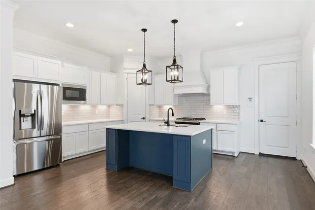 a kitchen with stainless steel appliances a sink a stove and a refrigerator