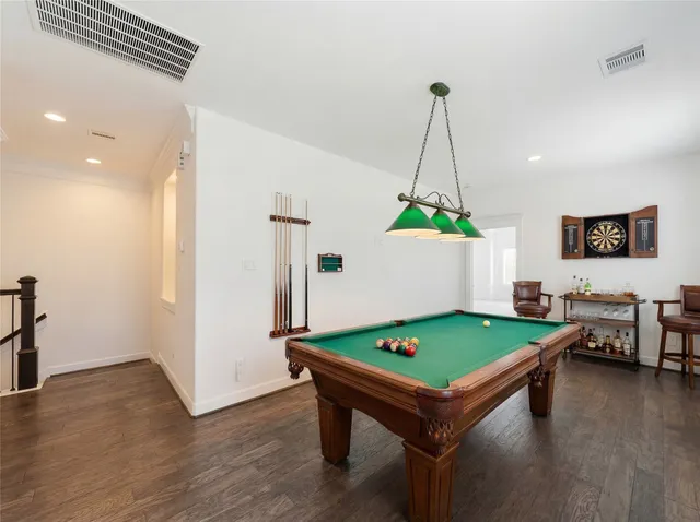 an empty room with wooden floor and a ceiling fan