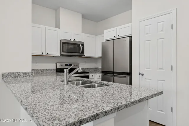 a kitchen with stainless steel appliances granite countertop a sink stove and microwave