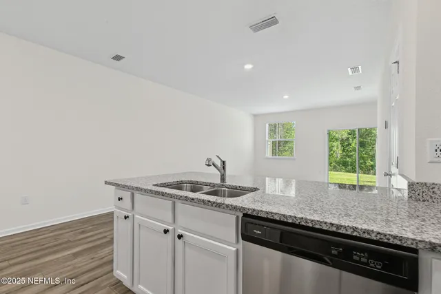 a kitchen with granite countertop cabinets sink and window