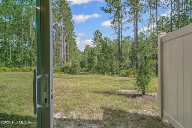 a view of a yard with trees in the background
