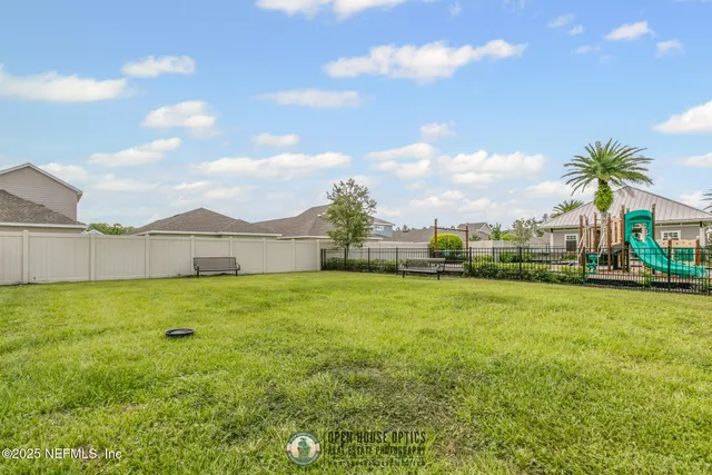 a view of a house with a backyard and a tree