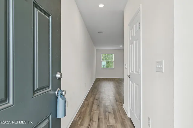 a view of a hallway with wooden floor and stairs