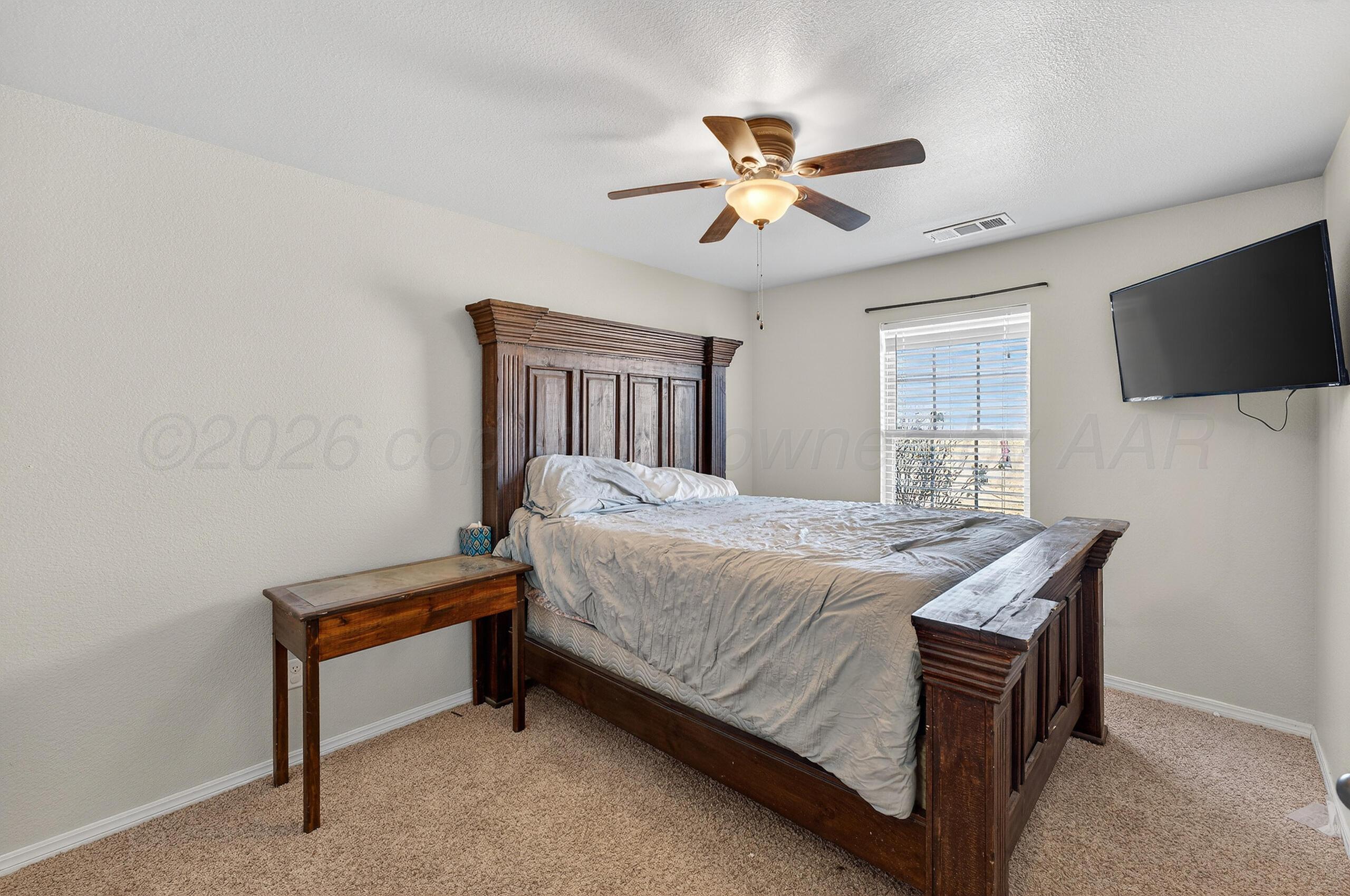 383 County Road 309 Panhandle, TX 79068 - Photo 19 of 35 a bedroom with a bed and a flat screen tv