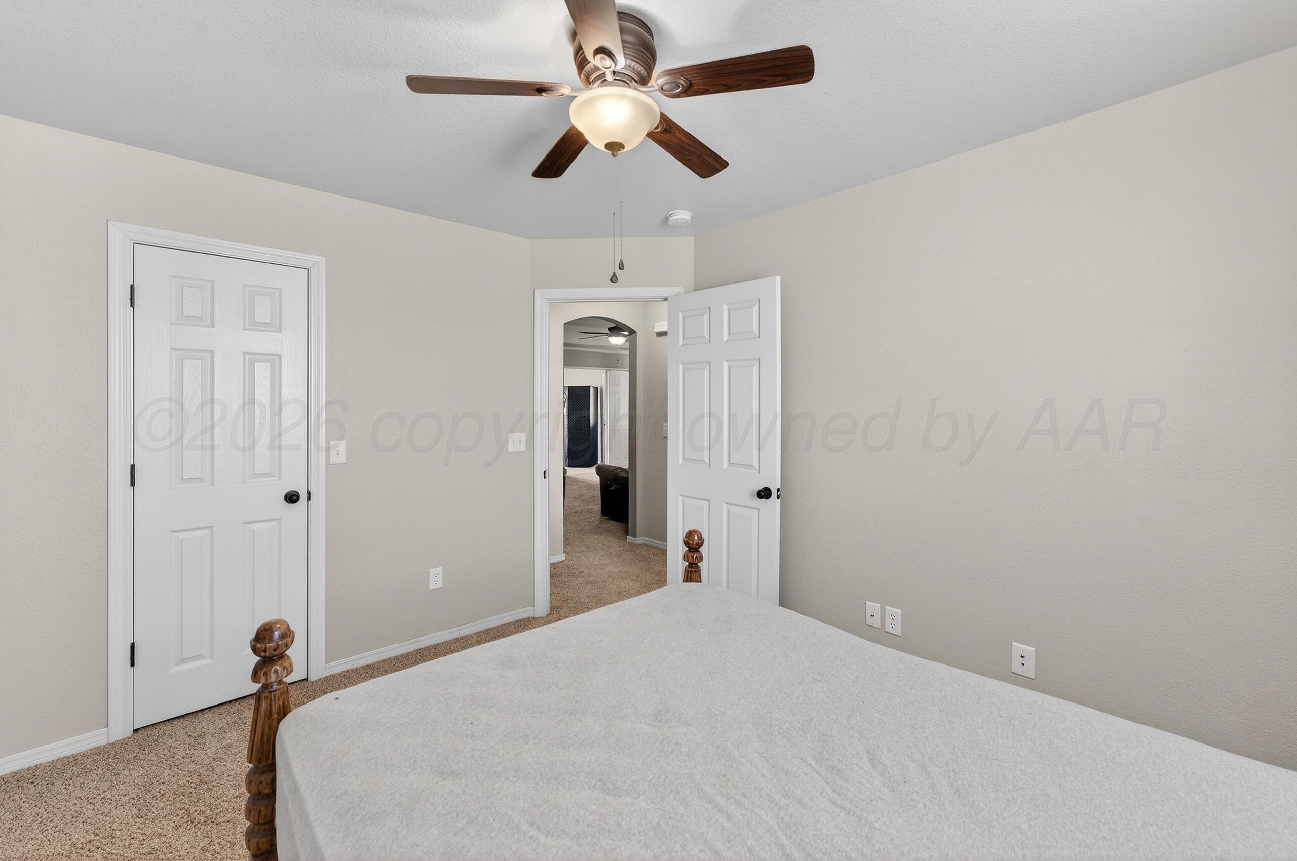 383 County Road 309 Panhandle, TX 79068 - Photo 21 of 35 a bedroom with a bed and a chandelier