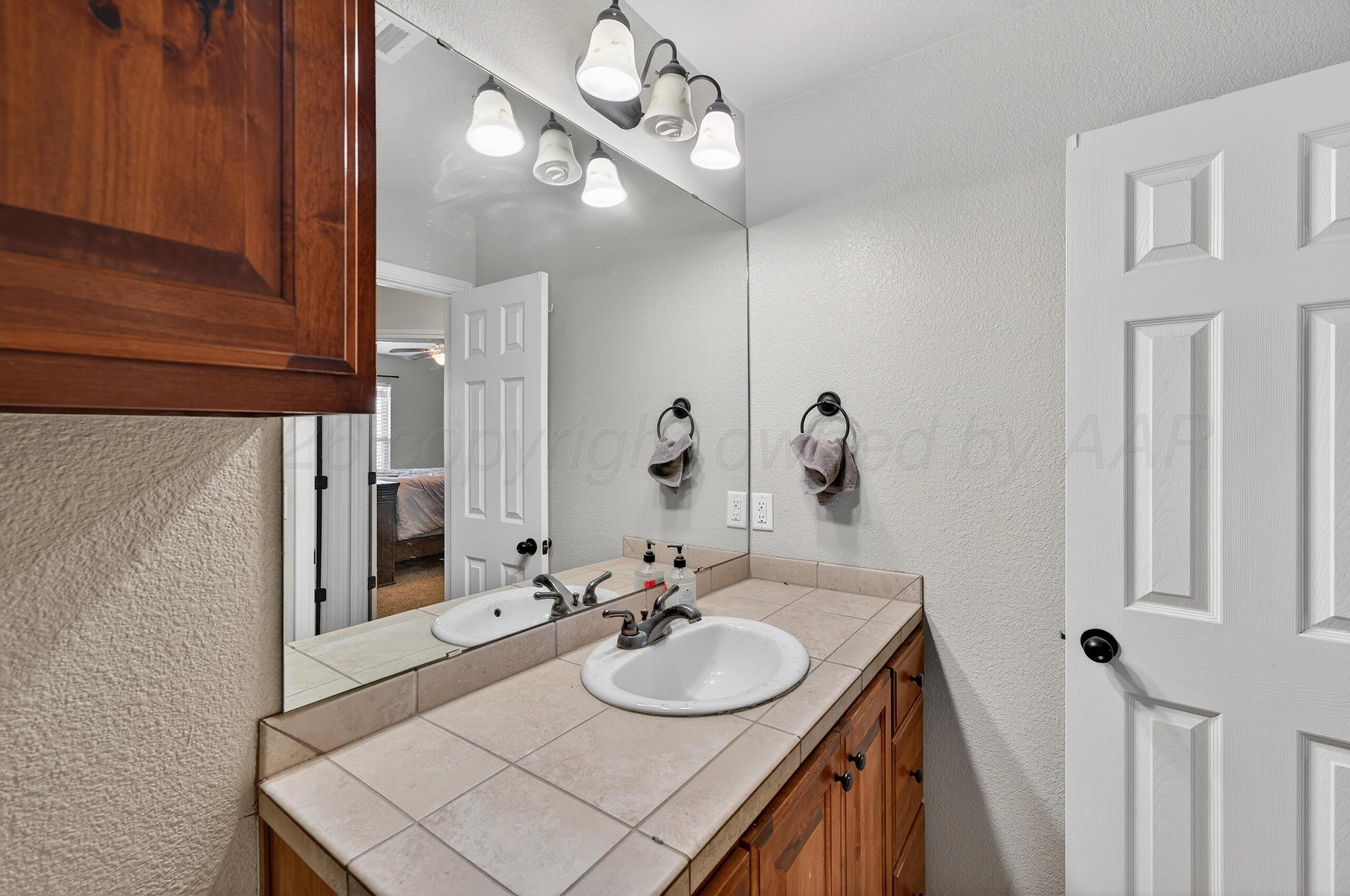 383 County Road 309 Panhandle, TX 79068 - Photo 23 of 35 a bathroom with a sink vanity and a mirror
