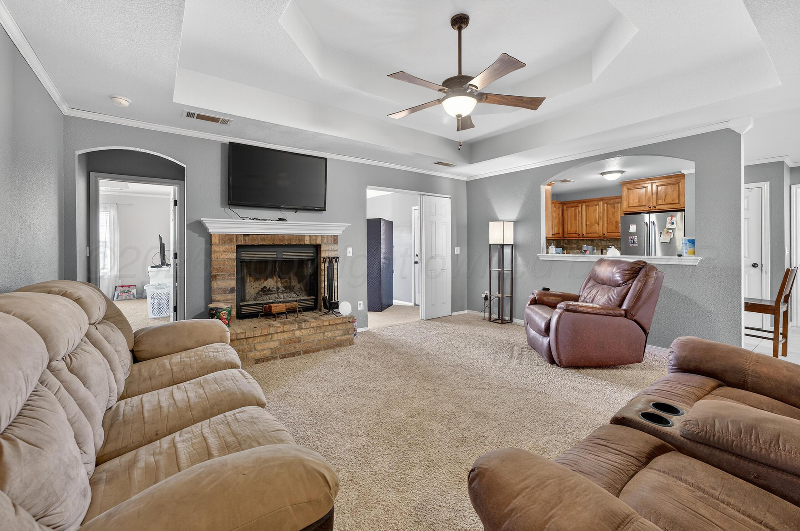 383 County Road 309 Panhandle, TX 79068 - Photo 3 of 35 a living room with furniture a flat screen tv and a fireplace