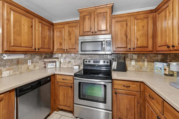a kitchen with granite countertop wooden cabinets and a stove top oven