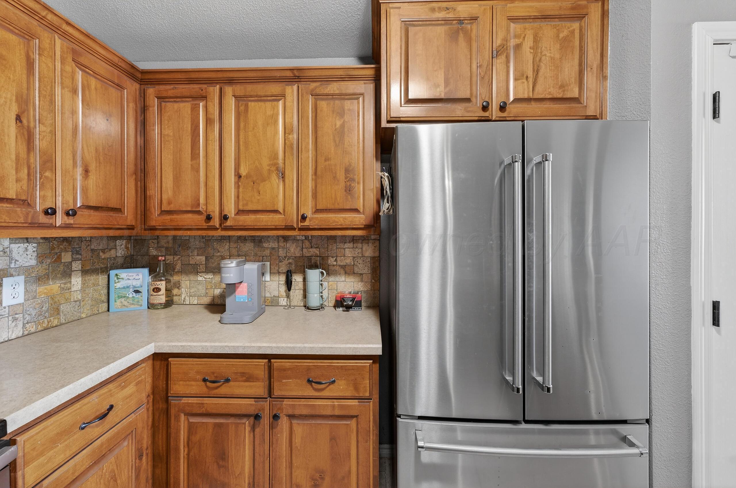 383 County Road 309 Panhandle, TX 79068 - Photo 10 of 35 a kitchen with a refrigerator and cabinets