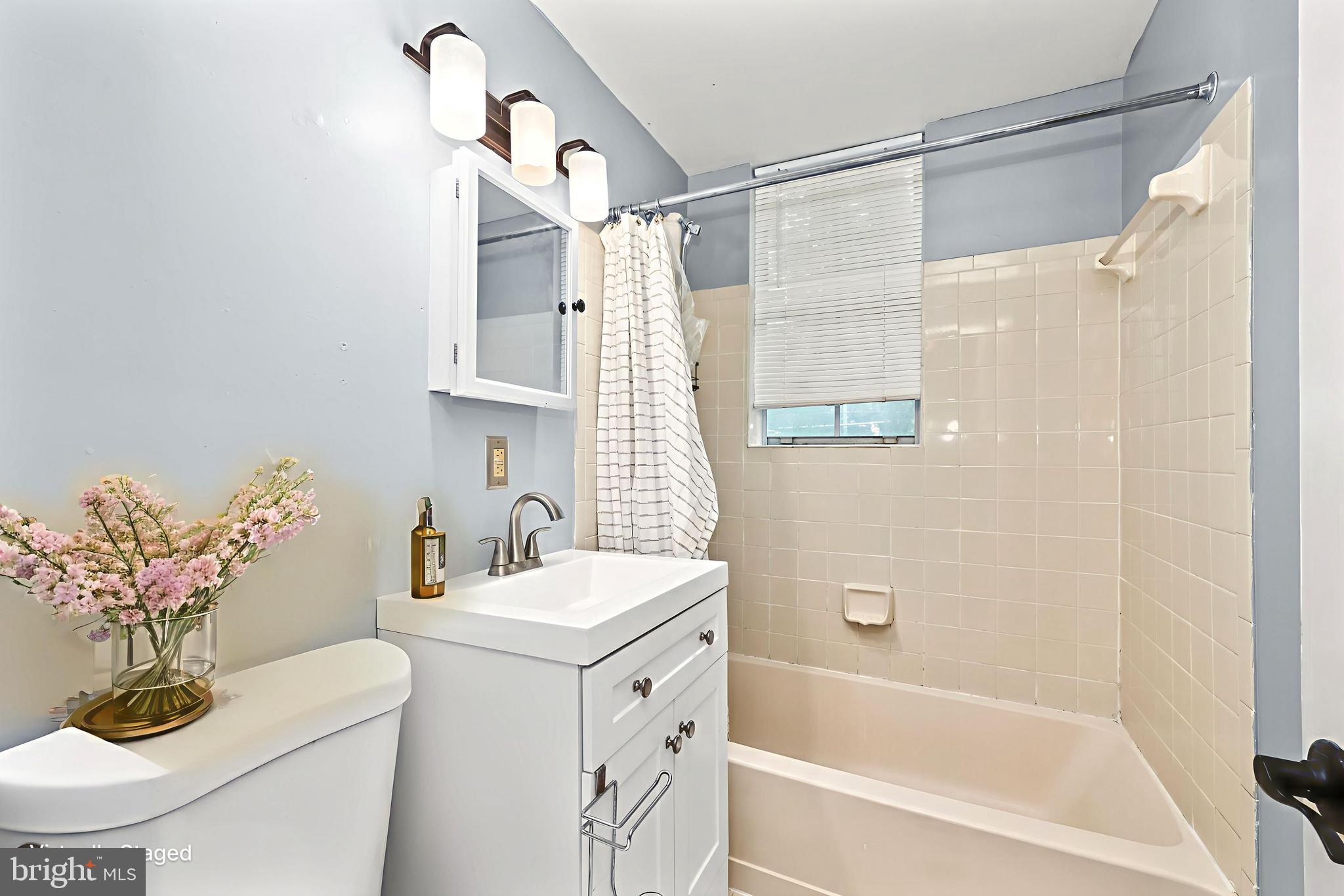 1802 Key Boulevard, Unit 9482 Arlington, VA 22201 - Photo 13 of 28 a bathroom with a sink a mirror a bathtub and shower