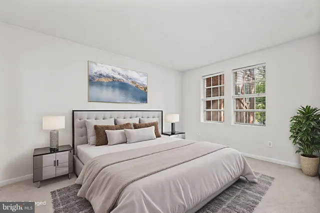 a bedroom with a large bed and a potted plant