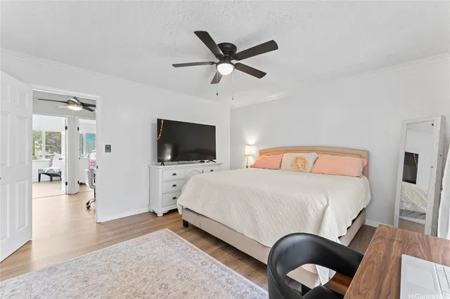 a bedroom with a bed a flat screen tv and a couch