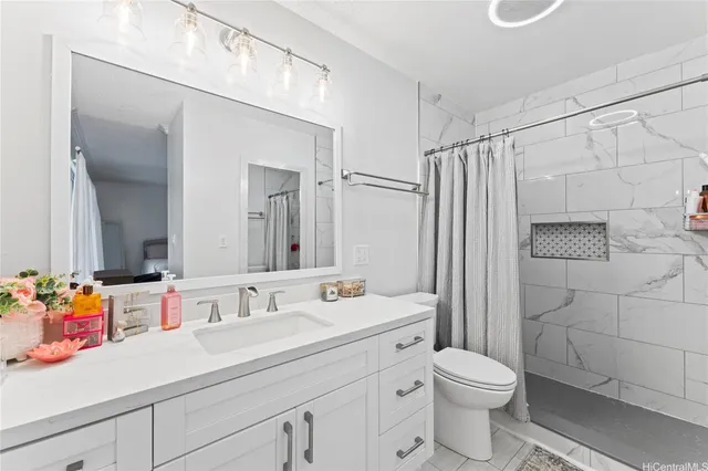 a bathroom with a sink toilet vanity and shower