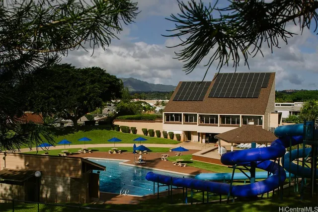 an aerial view of a house with swimming pool and next to a yard
