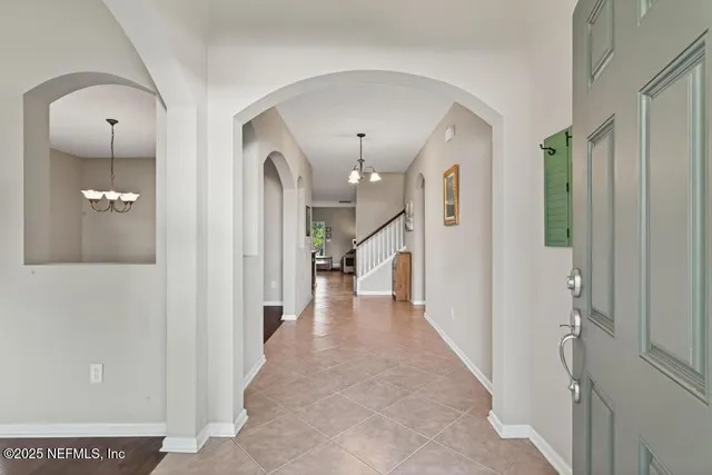 a view of a room with wooden floor chandelier and windows