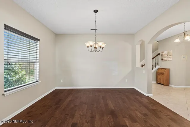 a kitchen with stainless steel appliances granite countertop a sink a stove a refrigerator a island with wooden cabinets and floor