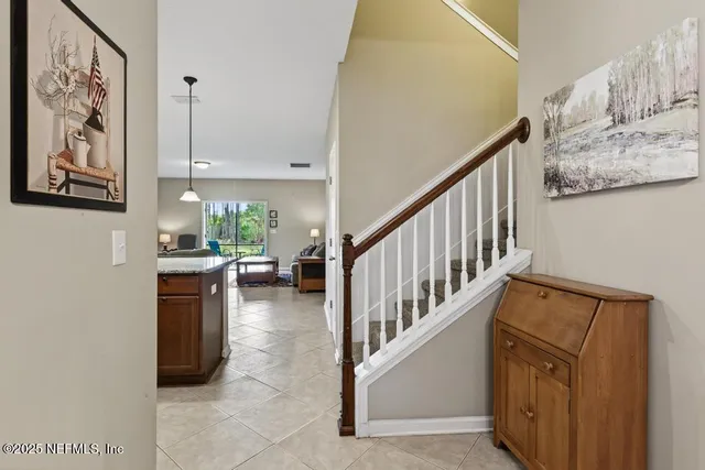 a bed sitting in a spacious bedroom next to a window and a dresser