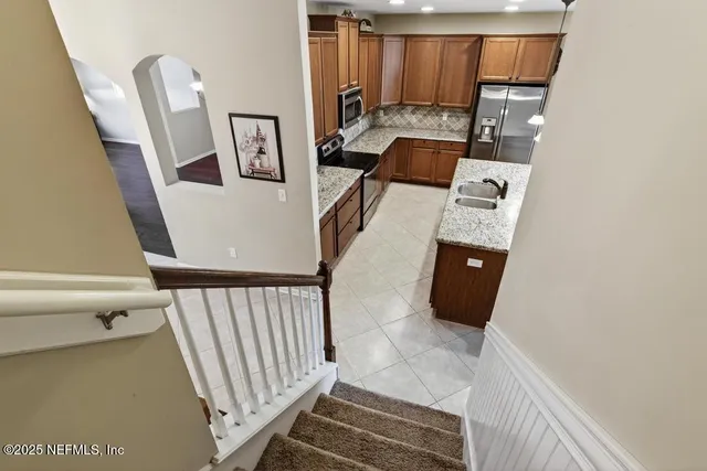 a backyard of a house with plants and large tree