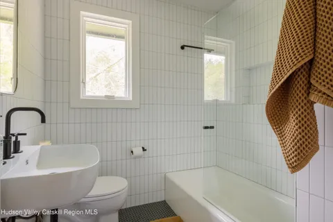 a bathroom with a sink a toilet and bathtub