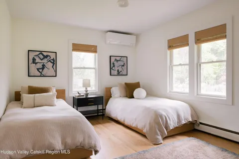 a bedroom with two beds and a window