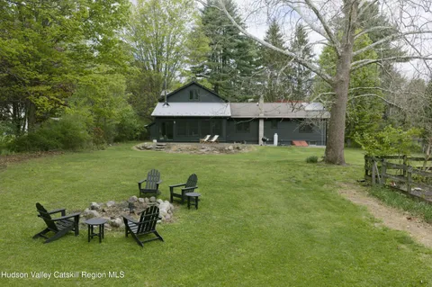 a backyard of a house with table and chairs
