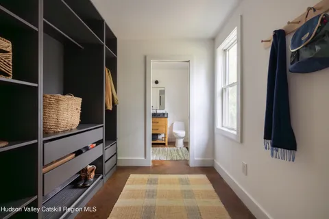 a view of a hallway with wooden floor and windows