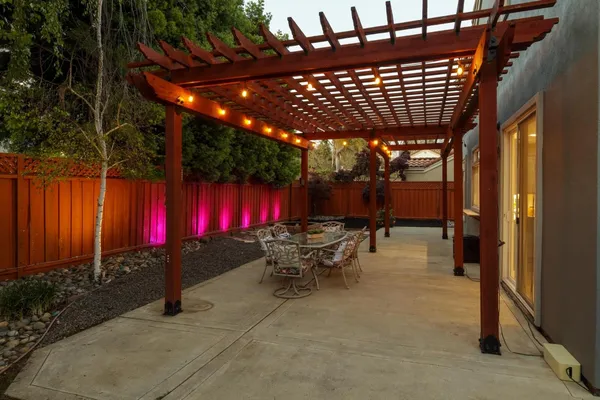 a view of a patio with table and chairs with wooden fence and plants