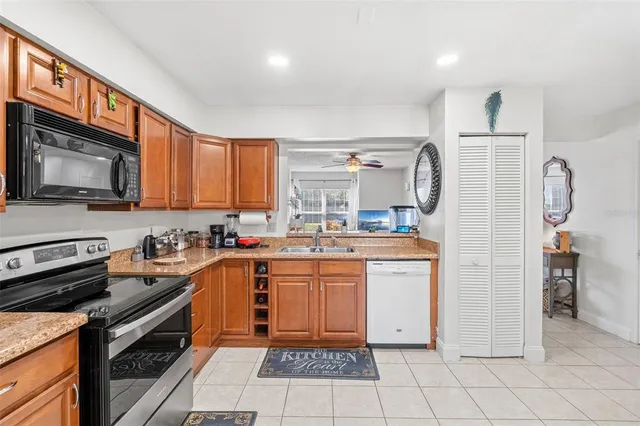 a kitchen with granite countertop appliances a sink and a refrigerator