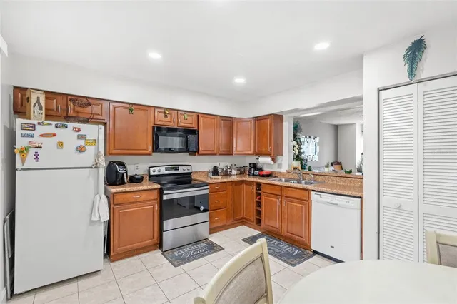 a kitchen with stainless steel appliances granite countertop a stove a sink and a refrigerator