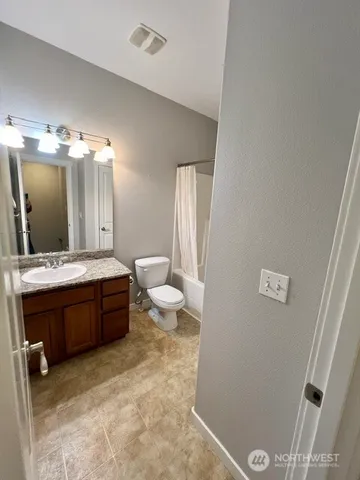 a spacious bathroom with a toilet sink and mirror
